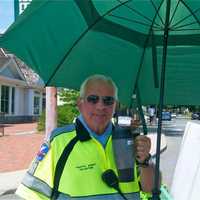 <p>A Westport traffic agent fighting heat with water and umbrella Sunday.</p>