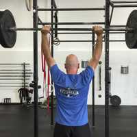 <p>CrossFit General Manager Tim Deenihan demonstrates a lift at the gym Tuesday.</p>