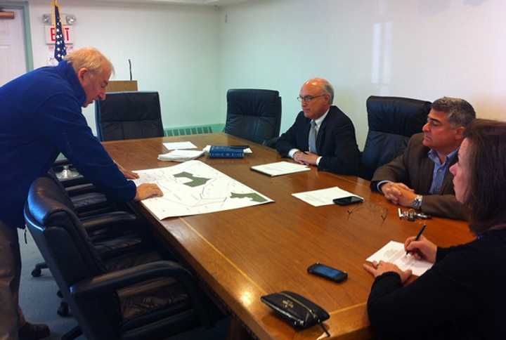 Benjamin Oko shows Ridgefield First Selectman Rudy Marconi and Selectmen Andrew Bodner and Maureen Kozlark a map of where the open space would be on Ledgers Road.