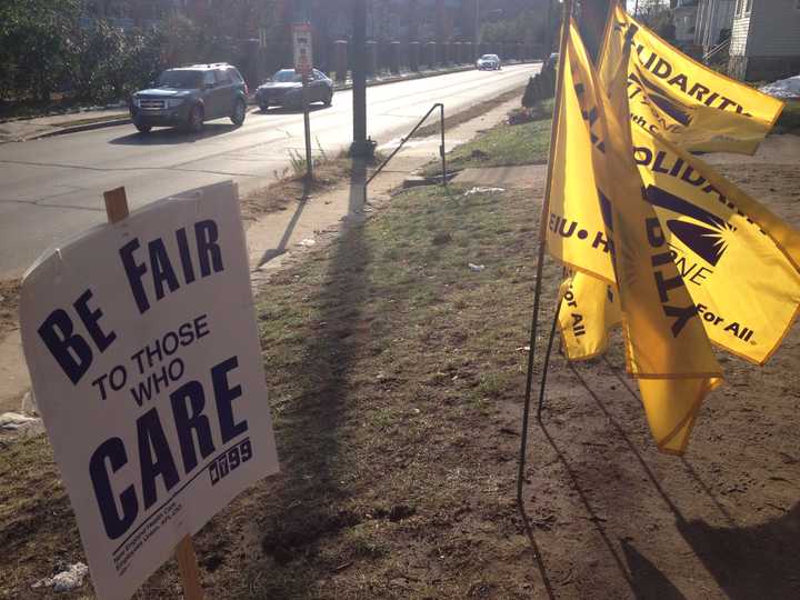 Picket signs line the property next to Danbury Health Care Center, where workers have been striking since July.