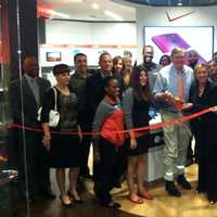 <p>Mayor David Martin, center, prepares to cut the ribbon at the expanded Verizon Wireless store at Stamford Town Center.</p>