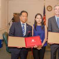 <p>White Plains Mayor Thomas Roach and White Plains Safety Commissioner David Chong received gifts from Chenglin Zhang (second from left) and Chang Liu (right) who represent the student delegation from Guizhou Province in China.</p>