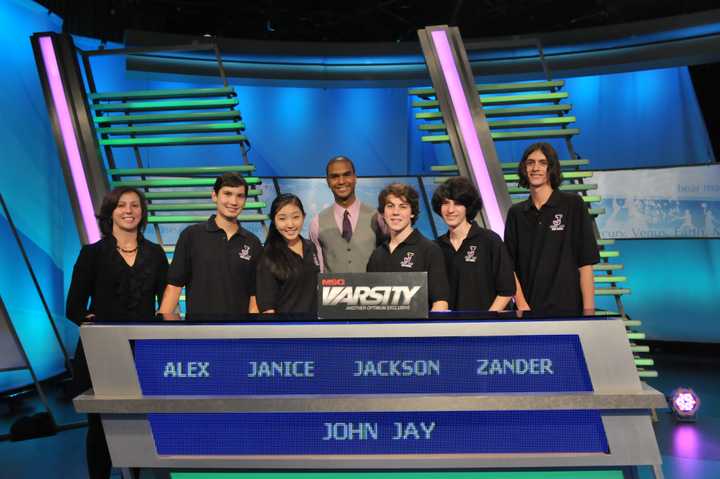 The John Jay students competing on The Challenge are, Alex Lee, Janice Choi  (alternate), Jackson Ruzzo (captain), Alexander Bolgar, and Angelo Angelino. At left is academic adviser Vicky Weiss and at center is &quot;The Challenge&quot; host Jared Cotter.