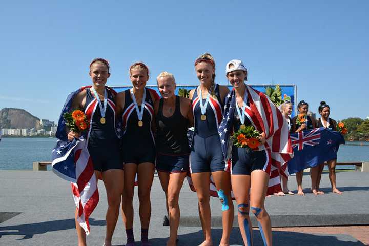 Ridgefield&#x27;s Kaitlyn Kynast, right, celebrates with coach Liz Trond (center) and teammates after winning the gold medal in the Women&#x27;s 4.