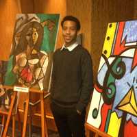 <p>Chris Watts displays his paintings at the Harlem Fine Arts Show in White Plains Thursday.</p>