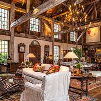 <p>The living room at 50 Zaccheus Mead Lane features soaringly high windows and massive stone fireplaces.</p>