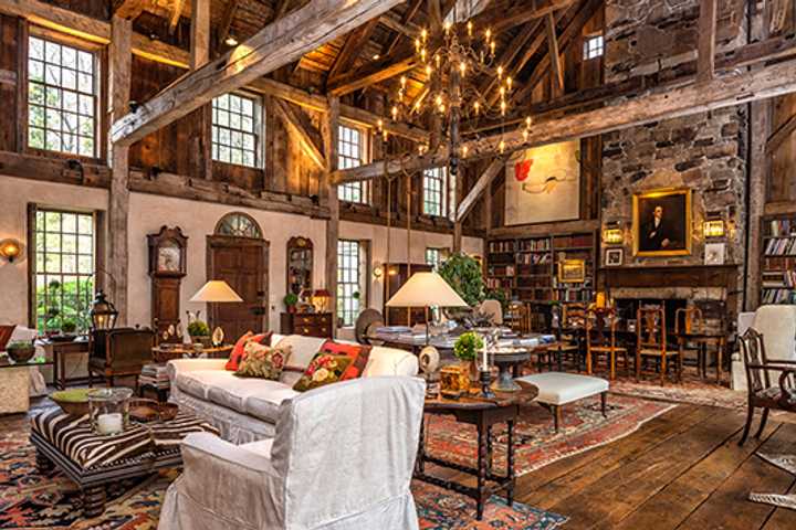 The living room at 50 Zaccheus Mead Lane features soaringly high windows and massive stone fireplaces.