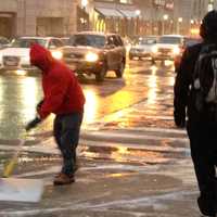 <p>A worker shovels snow off Main Street in front of Walmart in White Plains. </p>