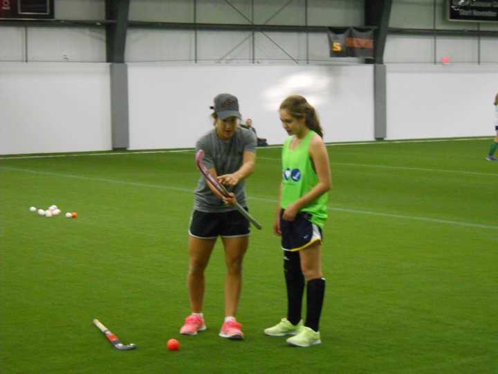 U.S. Olympic field hockey player and Lakeland graduate Melissa Gonzalez, left, works with a field hockey player during the Stars and Stripes Field Hockey clinic at the House of Sports.