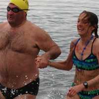 <p>Robin Myers, left, and Andrea Williamson emerge from the waters off Compo Beach in Westport Tuesday morning following the Team Mossman Polar Plunge to benefit Save the Children.</p>