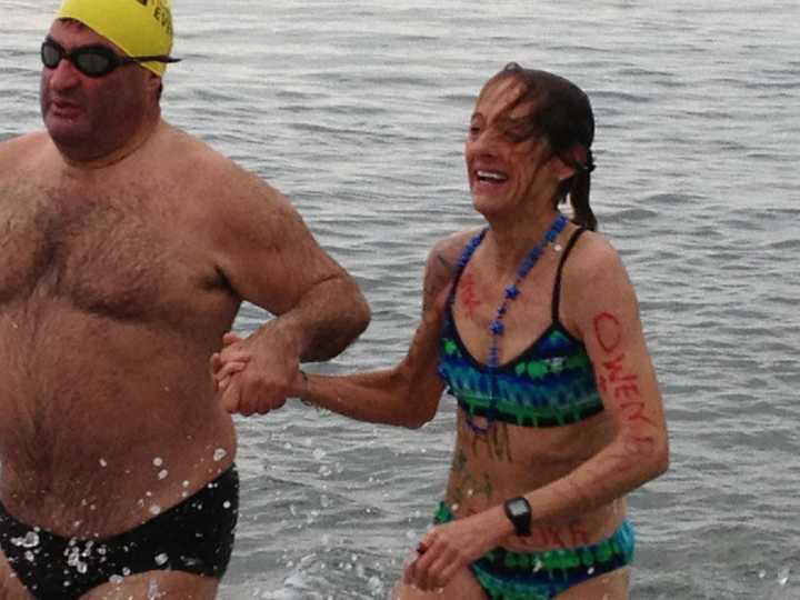 Robin Myers, left, and Andrea Williamson emerge from the waters off Compo Beach in Westport Tuesday morning following the Team Mossman Polar Plunge to benefit Save the Children.