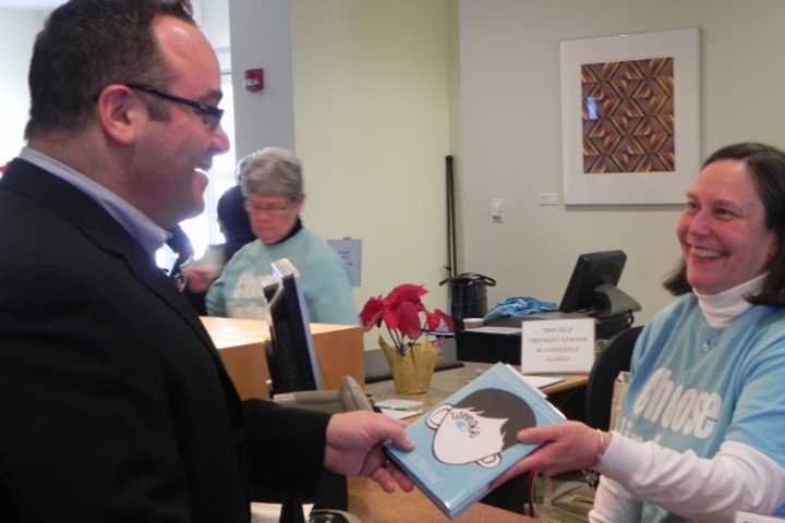 Bob Sussman, treasurer of Fairfield&#x27;s Board of Library Trustees, is one of the first to check out &quot;Wonder&quot; with the help of librarian Anne Farkas.