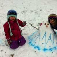 <p>Isabel Torgerson, 4, left, and her sister Charlotte, 7, spent part of their Friday making a snowgirl they named Marina outside of their New Canaan home. </p>