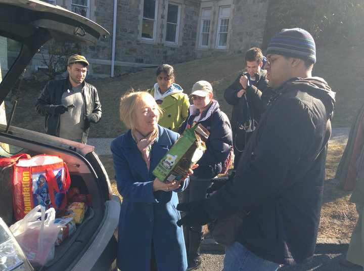 Kat Klein (left) hands Jared Roman (right) a bag of pet food to donate to the Hudson Valley Pet Food Pantry on Tuesday. 