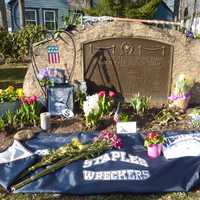 <p>Flowers, photos and sports items are placed on Veterans Green in Westport to memorialize fallen Westport Marine Roger Muchnick. </p>