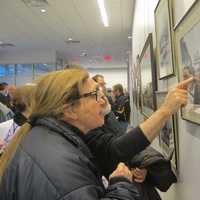 <p>Ossining residents examine photographs and artwork displayed at the Ossining Public Library honoring the Village of Ossining&#x27;s Bicentennial. </p>