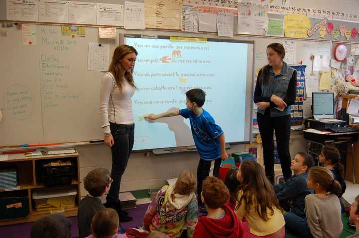 Second-grader Christian Bellantoni participates in a language activity conducted by high school juniors Samantha Steiner (left) and Amanda Tantleff. 