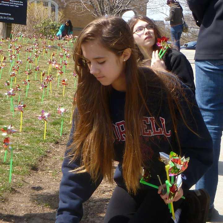 Catalina Ruiz-Jimenez of Greenwich plants a pinwheel representing one of almost 2,000 children abused or neglected in Fairfield County last year.