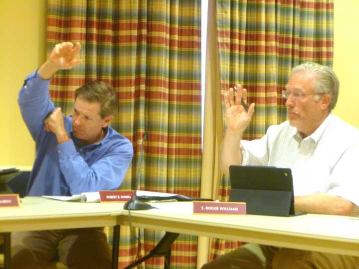 Town Council members Robert Hamill (left) and E. Roger Williams vote in favor of New Canaan&#x27;s spending plan. 