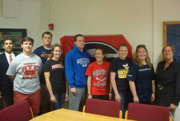 Rye High School student athletes with Athletic Director Rob Castagna and Principal Patricia Taylor at a signing ceremony Thursday.