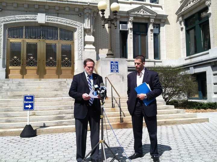 Former Yonkers Mayor Philip Amicone reads from a letter of apology as Sam Zherka looks on outside City Hall Wednesday. 