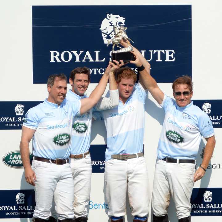 Prince Harry and his teammates hold up the trophy after winning the Sentebale Royal Salute Polo Cup at the Greenwich Polo Club.