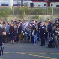 <p>Passengers wait for buses to take them away from the scene of a two-train collision.</p>