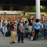 <p>Passengers wait for buses to take them away from the scene of a two-train collision.</p>