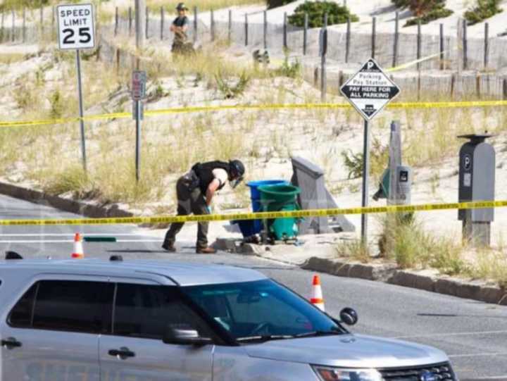 An Ocean County Sheriff&#x27;s Bomb Squad member inspects the other cans next to the one the exploded.