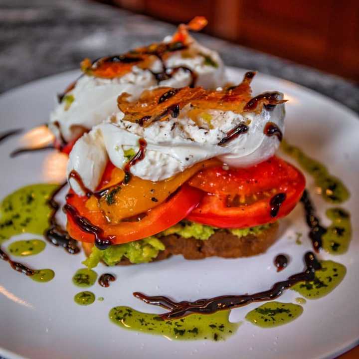 Burrata Avocado Toast with fresh mozzarella, avocado spread, roasted peppers, heirloom tomatoes, candied prosciutto, reduced balsamic and basil oil from ITA Kitchen, newly opened at 45 West Main Street in Bay Shore