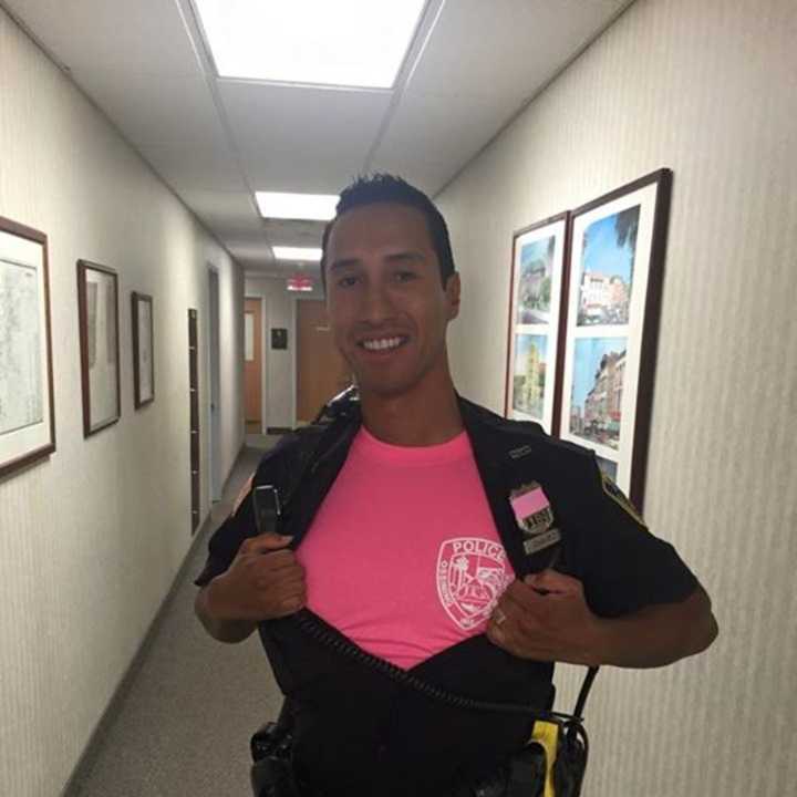 Ossining Police are selling a limited quantity of their pink department shirts, as displayed by Police Officer Addison Chavez. 