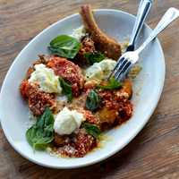 <p>Pork Chop Parmesan at Amis Westport. The new restaurant will open at the end of March on Church Lane.</p>