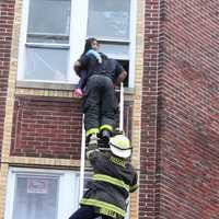 <p>City firefighter Ricardo Figueroa climbed a ground ladder and carried the child down with help from Deputy Chief Chris DiBella.</p>