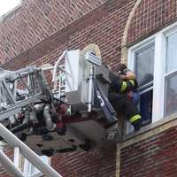 <p>The mom is brought down via a firetruck ladder during Monday&#x27;s rescue in Passaic.</p>