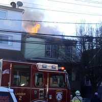 <p>Flames blew through the roof of the Harrison Street home in Passaic.</p>