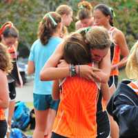 <p>Girls on the Ridgefield High School cross country team embrace after Tuesday&#x27;s meet.</p>