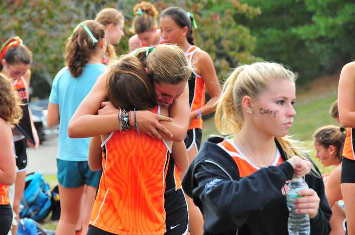 Girls on the Ridgefield High School cross country team embrace after Tuesday&#x27;s meet.