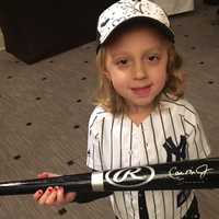 <p>Callie holds a Cal Ripken, Jr. autographed baseball bat.</p>