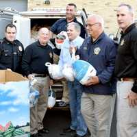 <p>Bergen County Sheriff Michael Saudino with County Executive Jim Tedesco (to his right) and others delivering turkeys at the CFA in Saddle Brook. Far right is BCSO Officer Aret Yesilepe, who organized the first the drive 7 years ago.</p>