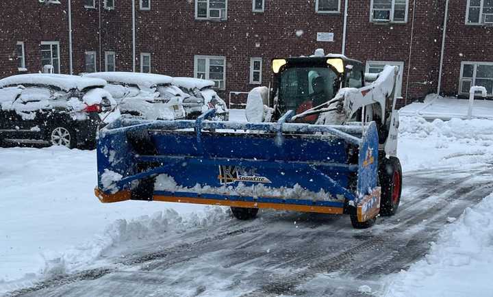 A snowplow clearing a parking lot.