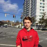 <p>Stamford High student Christian Hamilton, with Stamford High in the far background. He said an announcement over the loudspeaker system told everyone to evacuate the school on Tuesday.</p>