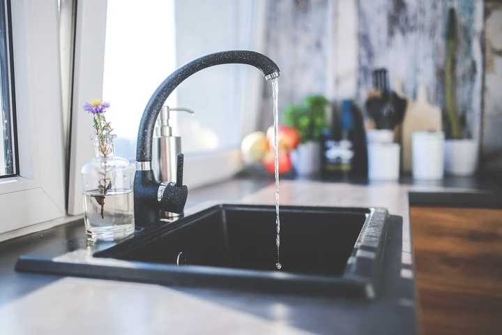 A sink with a running water faucet.