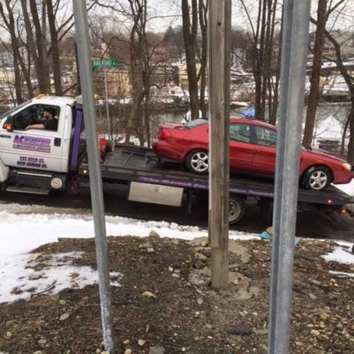 The car that was hit by a Danbury-bound train on Tuesday afternoon is towed from the scene of the accident in Norwalk.