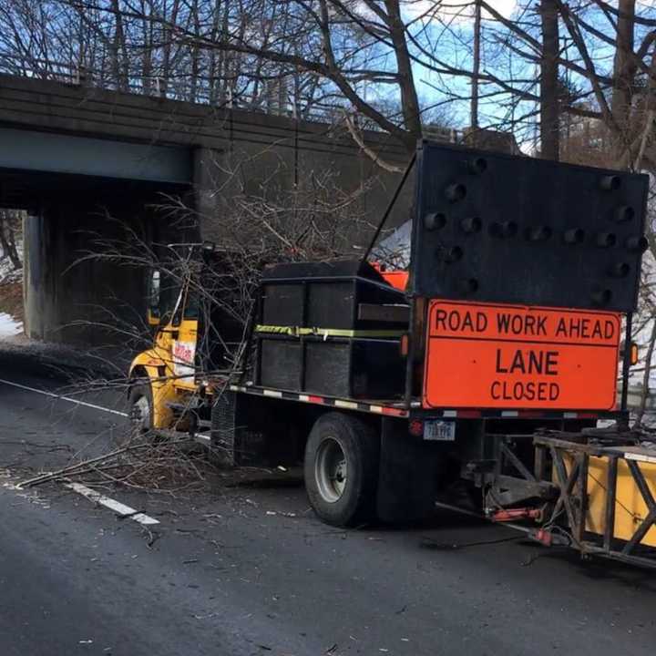 High winds sent a tree branch crashing down on contractors workers on I-95 in Greenwich on Monday.