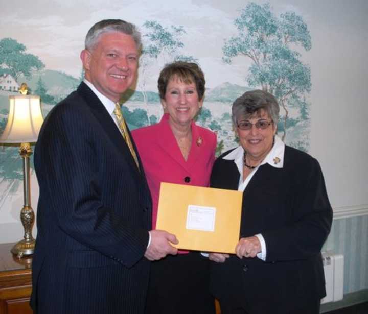 Paul and Karen Van Ostenbridge present a donation to Eva&#x27;s Village on behalf of Atlantic Stewardship Bank&#x27;s tithing program. 