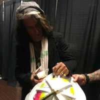 <p>Aerosmith lead guitarist Joe Perry signing the Allendale leather fire helmet.</p>