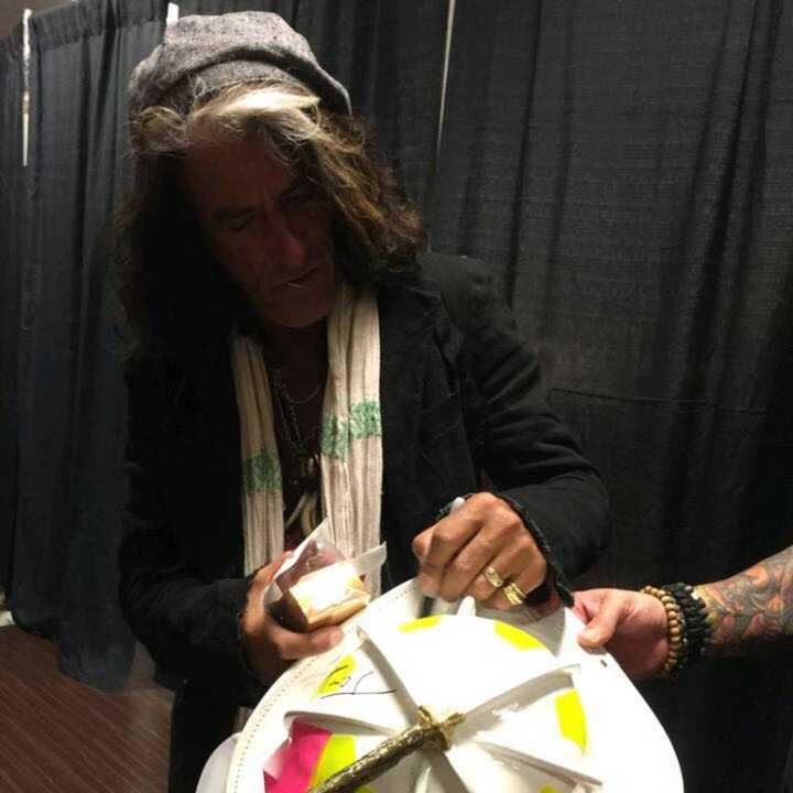 Aerosmith lead guitarist Joe Perry signing the Allendale leather fire helmet.