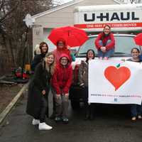 <p>Amber Lewis, the founder of Greater NYC Families for Syria, sits on top of the U-Haul truck at their first-ever donation event in Eastchester surrounded by other volunteers.</p>