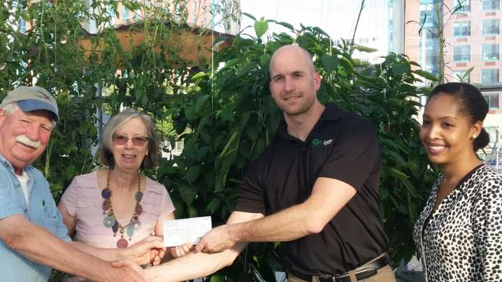 Ann-Marie Mitroff, receiving a check for $10,000 from Matt Shue, the Domino plant’s refinery manager.