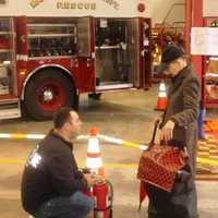 <p>Firefighter Jim Scanga answers a resident&#x27;s question about household fire extinguishers</p>